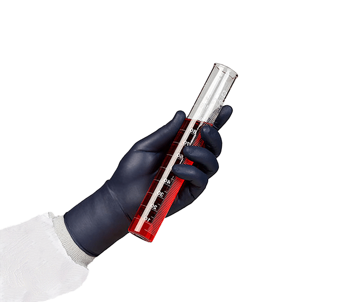 A person's arm in PPE with a black nitrile glove holding a testube with red liquid.